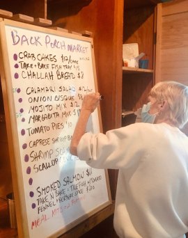 Local Business Evolves for 2020 Tricia Palmisano adjusts the dry erase board to reflect item changes for the day.