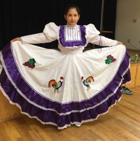Ballet Folklorico de Ocracoke Dellanira Romero models a dress from the Aguascalientes dance featuring the traditional emblems of grapes and fighting roosters.