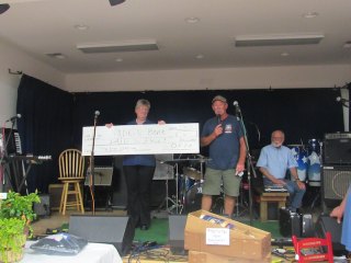 Paid In Full Auctioneer Philip Howard takes a break while Ernie makes the check presentation to Judy.