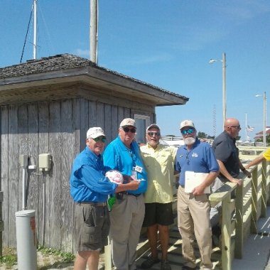 285 Ride Ocracoke Express Inaugural passengers Archer Watkins (left) & Charlie Batchelor (second from right) pose with Ferry Division employees John McKenzie & LB Johnson. Capt. Watkins & Capt. Batchelor sailed to Ocracoke on their own boats then rode the Ocracoke Express for fun.